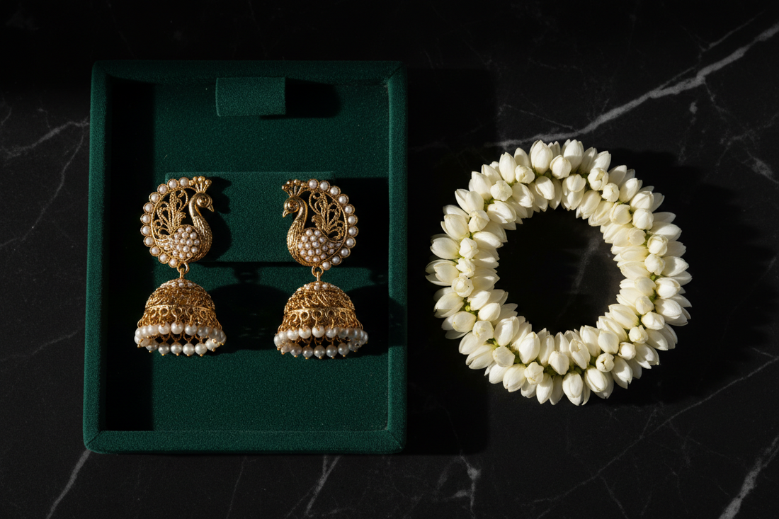 Gold peacock jhumka earrings with pearl detailing on dark green velvet with jasmine garland — ethnic jewellery by Taniva